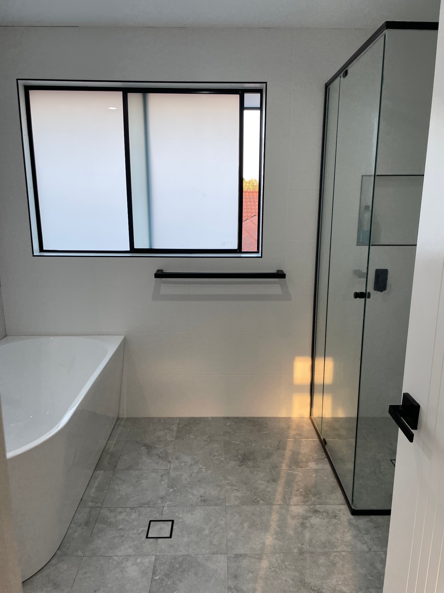 Macarthur bathroom renovation — wide view with bath, shower and feature window