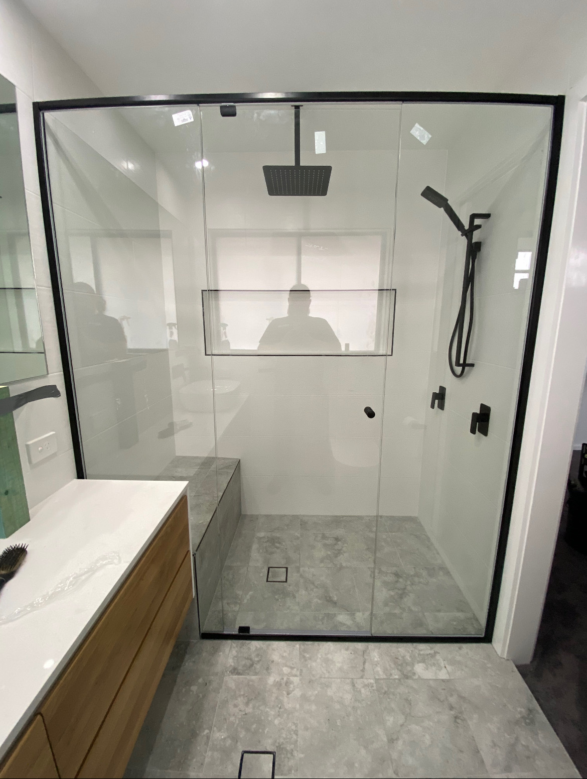 Frameless glass shower with rainhead, handheld and matte black tapware — Macarthur bathroom renovation